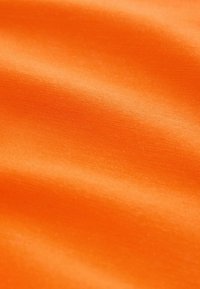 Tissu en satin orange vif avec une finition lisse et brillante, présentant une texture douce et un éclat subtil, affichant des ondulations douces.