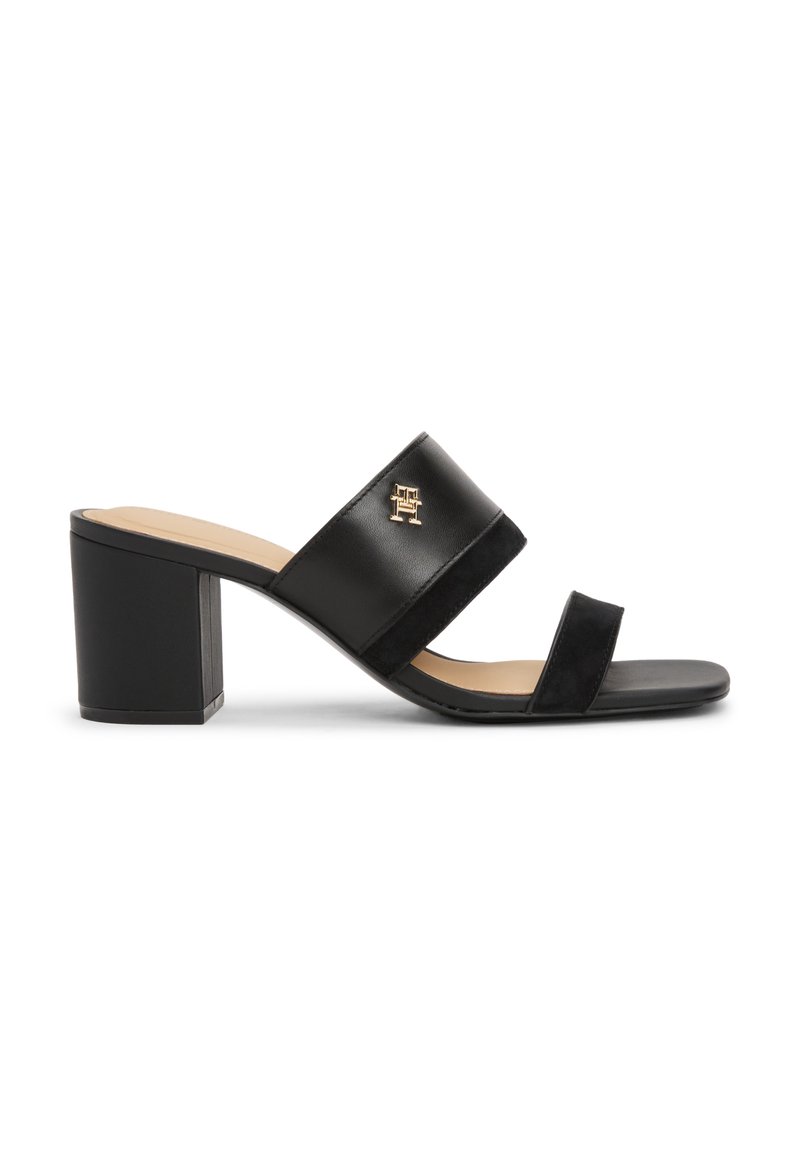 Schwarze Sandalen mit hohen Absätzen und zwei breiten Riemen – einer aus glattem Leder und einer aus Wildleder. Mit einem Blockabsatz und einem goldenen Logo-Highlight.