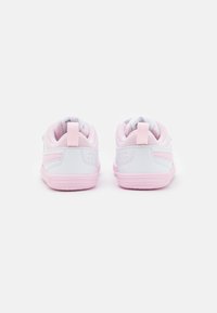 Białe sneakersy z różowymi akcentami, z górą z gładkiej skóry, z siateczkowymi detalami i solidną gumową podeszwą. Dwa uchwyty przy pięcie.