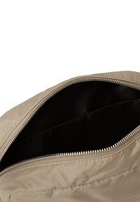 Borsa in nylon beige con apertura con zip, dotata di una fodera interna nera e texture liscia. Nessun motivo esterno o hardware visibile.