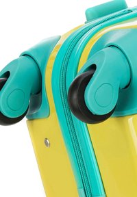 Valise rigide jaune avec des accents turquoise ; dotée d'une texture lisse, d'une fermeture éclair robuste et de roues rotatives doubles pour une mobilité aisée.