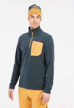 Fleece pullover in donkerblauw met een kwart-rits en een gele borstzak. Bevat textuurstof en een bijpassende beanie met branding.