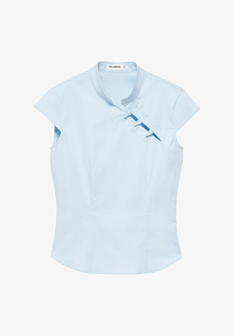Blouse sans manches bleu clair avec col mandarin et trois boutons noués en tissu le long de la partie supérieure droite de la poitrine.