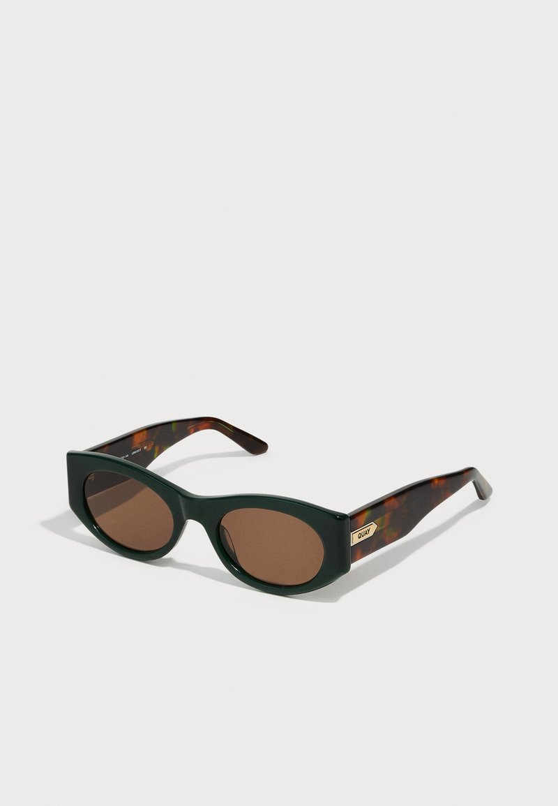 Ochelari de soare cu ramă verde patrată, lentile maro, brațe din material tartan și detaliu cu logo auriu pe lateral. Finisaj mat cu textură netedă.