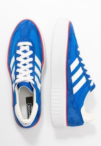 Blue suede and mesh sneakers with white stripes and laces, featuring a padded collar and a thick white sole accented with red.
