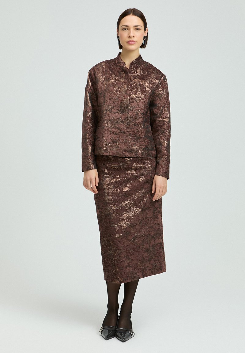 Bronze und dunkelbraunes, strukturiertes Zweiteiler-Outfit: taillierte Jacke mit hohem Kragen und knielangem Rock, akzentuiert mit einem dezenten metallischen Glanz.