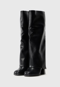 Black knee-high boots made of smooth leather, featuring a wide upper that drapes. Block heel provides stability, with a sleek, minimal design.