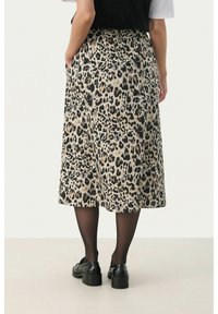 Jupe midi imprimée léopard avec une silhouette fluide, une taille élastique et un tissu doux. Associe-la avec des collants opaques noirs et des chaussures.