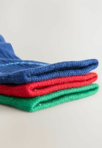 Drei Paare gefalteter Socken in Blau, Rot und Grün, die ein strukturiertes Strickdesign zeigen. Jedes Paar verfügt über einen gerippten Bund.