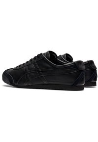 Black leather sneakers with a smooth finish, rounded toe, and textured rubber sole. Features stitched accents and logo at the heel.