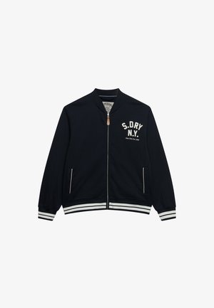 Mørkeblå jakke med lynlås med hvide stribede manchetter og kant, frontlommer og teksten "S.DRY N.Y." på brystet.