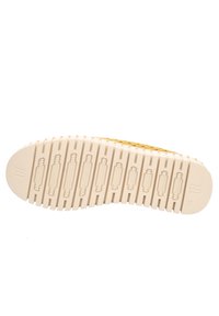 Suola di scarpa in materiale gommoso testurizzato, con scanalature e creste verticali. Il colore è beige chiaro con un marchio discreto che riporta il numero "38".