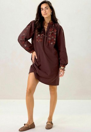 Brown cotton dress with long puff sleeves, embroidered floral patterns in red and beige, and a buttoned placket at the neckline.