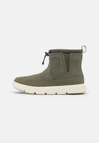 Green suede ankle boot with a textured collar, elastic side panels, white rubber sole, and pull tab. Features a branded logo on the side.