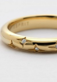 Goldfarbener metallischer Ring mit sternförmigen Akzenten, die mit kleinen Diamanten besetzt sind, glatte Oberfläche mit polierter Oberfläche.