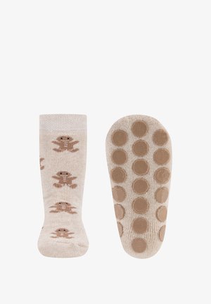 Knit socks in light beige featuring brown gingerbread man prints. Bottom has rubber grips in circular pattern for added traction.
