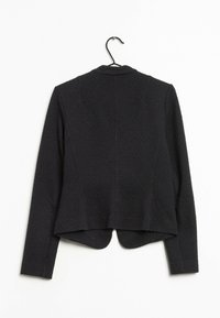 Blazer nero con un motivo testurizzato, vestibilità sagomata e orlo arrotondato. Presenta maniche lunghe e un colletto classico.