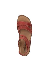 Red leather sandal with two straps and an open toe. Smooth texture and visible stitching detail along the sole. Neutral insole.