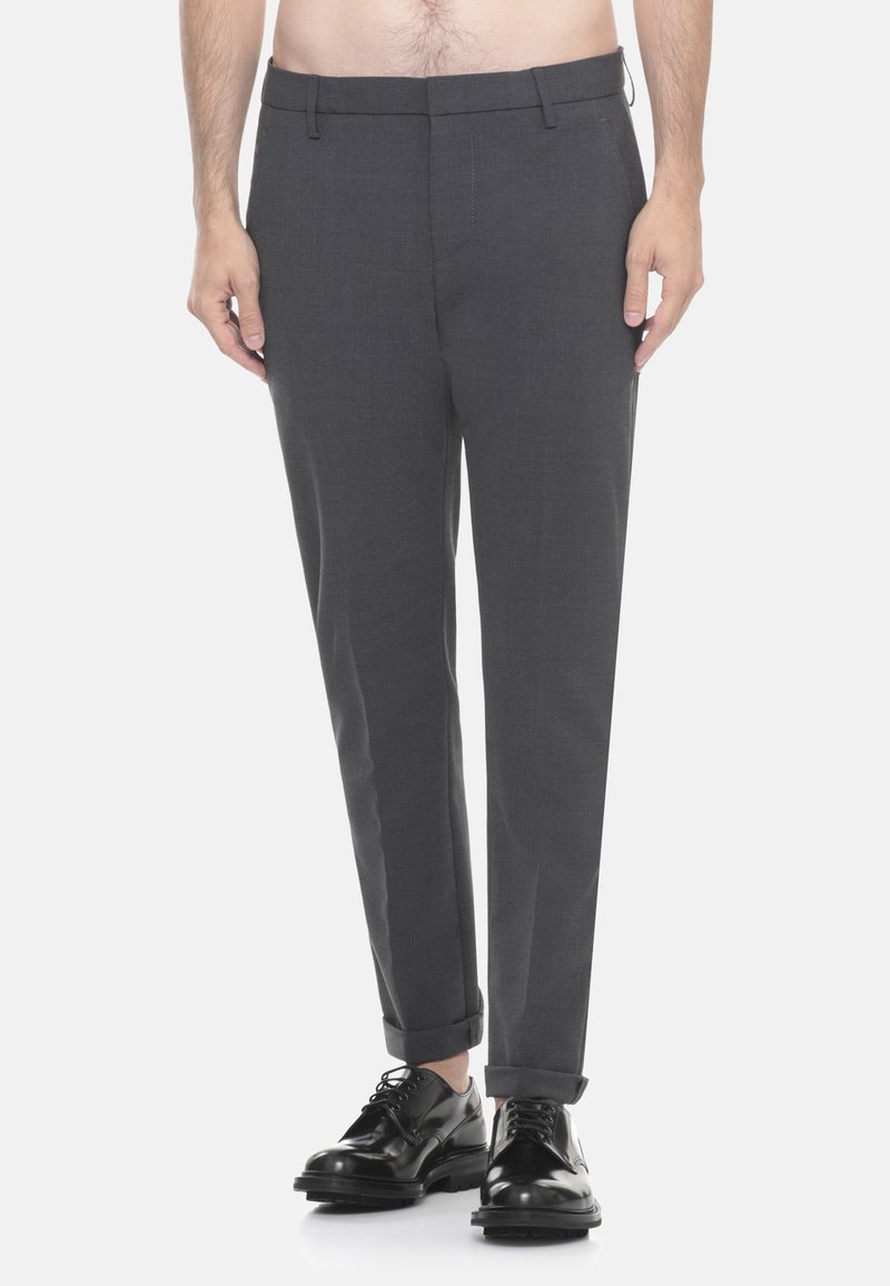 Pantaloni grigi su misura con vestibilità slim, pieghe frontali e risvolti, abbinati a scarpe eleganti nere. Tessuto liscio con una texture sottile.