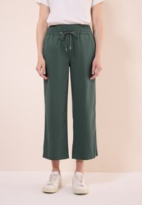 Grüne, weite Hosen mit einem elastischen Bund und Kordelzug. Hergestellt aus einem leichtgewichtigen Stoff, mit glatter Textur und cropped Länge.