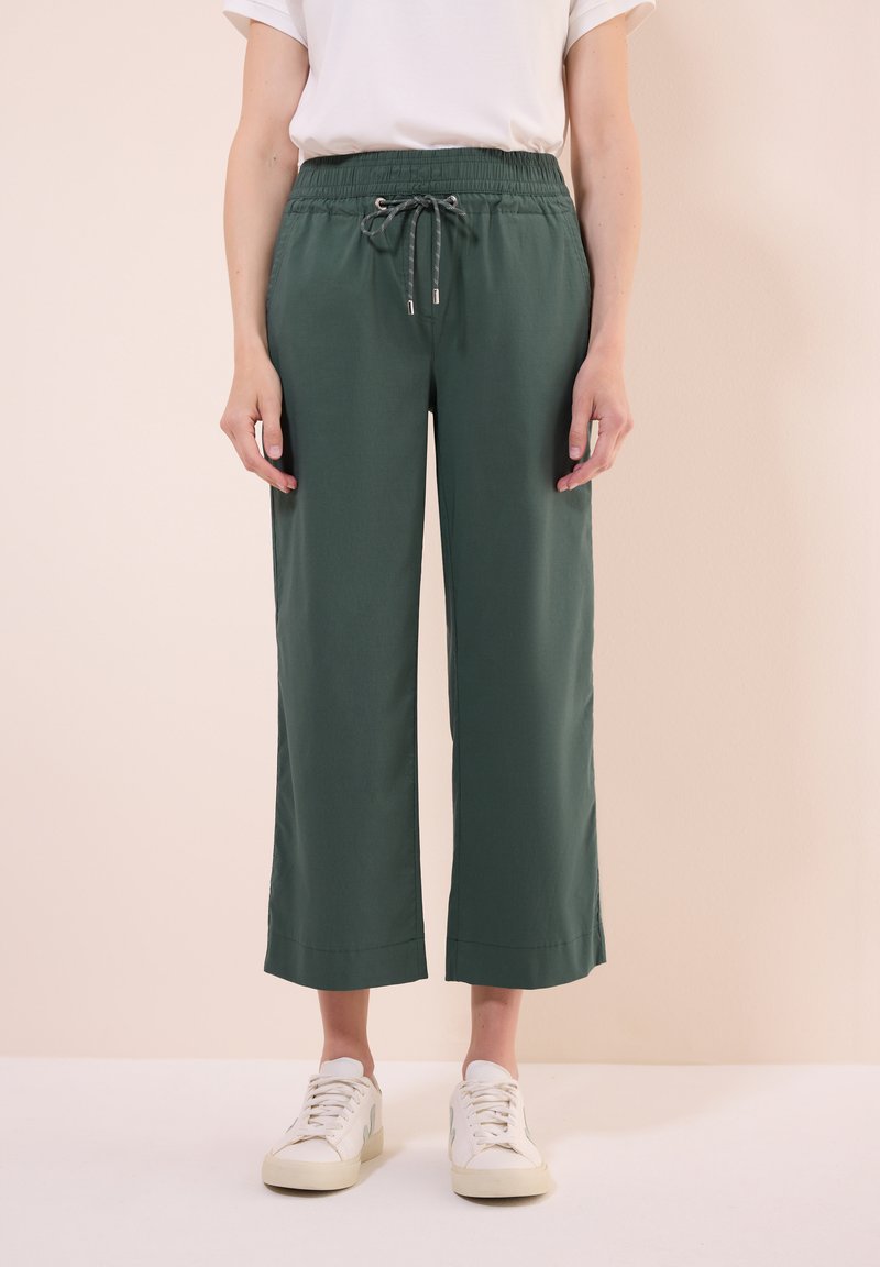 Grüne, weite Hosen mit einem elastischen Bund und Kordelzug. Hergestellt aus einem leichtgewichtigen Stoff, mit glatter Textur und cropped Länge.