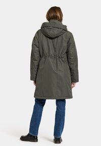 Olivgrüne Parkajacke mit Kordelzug in der Taille, Kapuze und lockerer Passform, verfügt über eine glatte Textur und ein mittellanges Design.