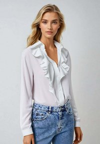 Chemise blanche à manches longues avec un col volants et un devant orné de boutons. Associée à un jean en denim clair avec un motif floral texturé.