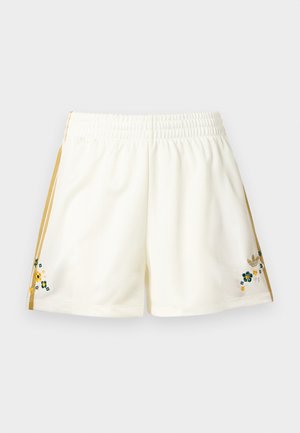 Cream-colored athletic shorts with gold side stripes and small embroidered green, yellow, and white flowers near the hem on both sides.