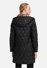Zwarte gewatteerde jas met een capuchon, voorzien van een kraag met luipaardprint, lange mouwen en een rechte pasvorm, ontworpen voor warmte en comfort.
