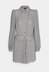 Abito a motivi in bianco e nero con scollo a colletto, maniche lunghe e bottoni sul davanti. Presenta una vita definita e una gonna arricciata.