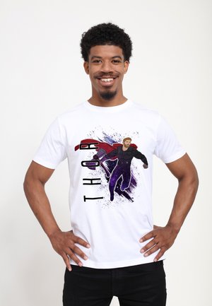 Hvid bomulds t-shirt med en trykt illustration af Thor i et lilla og sort outfit, med "THOR" i fede bogstaver ved siden af.