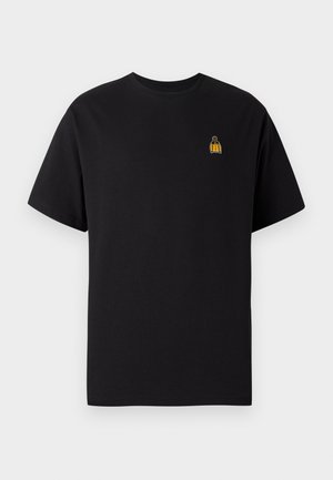T-shirt noir en coton à manches courtes, col rond, avec un petit motif brodé jaune sur le côté gauche de la poitrine.