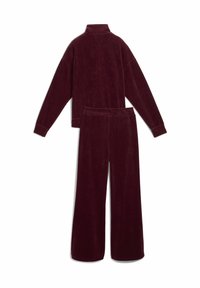 Burgundy corduroy loungewear set featuring a high-neck pullover with long sleeves and wide-leg pants. Textured fabric with ribbed pattern.