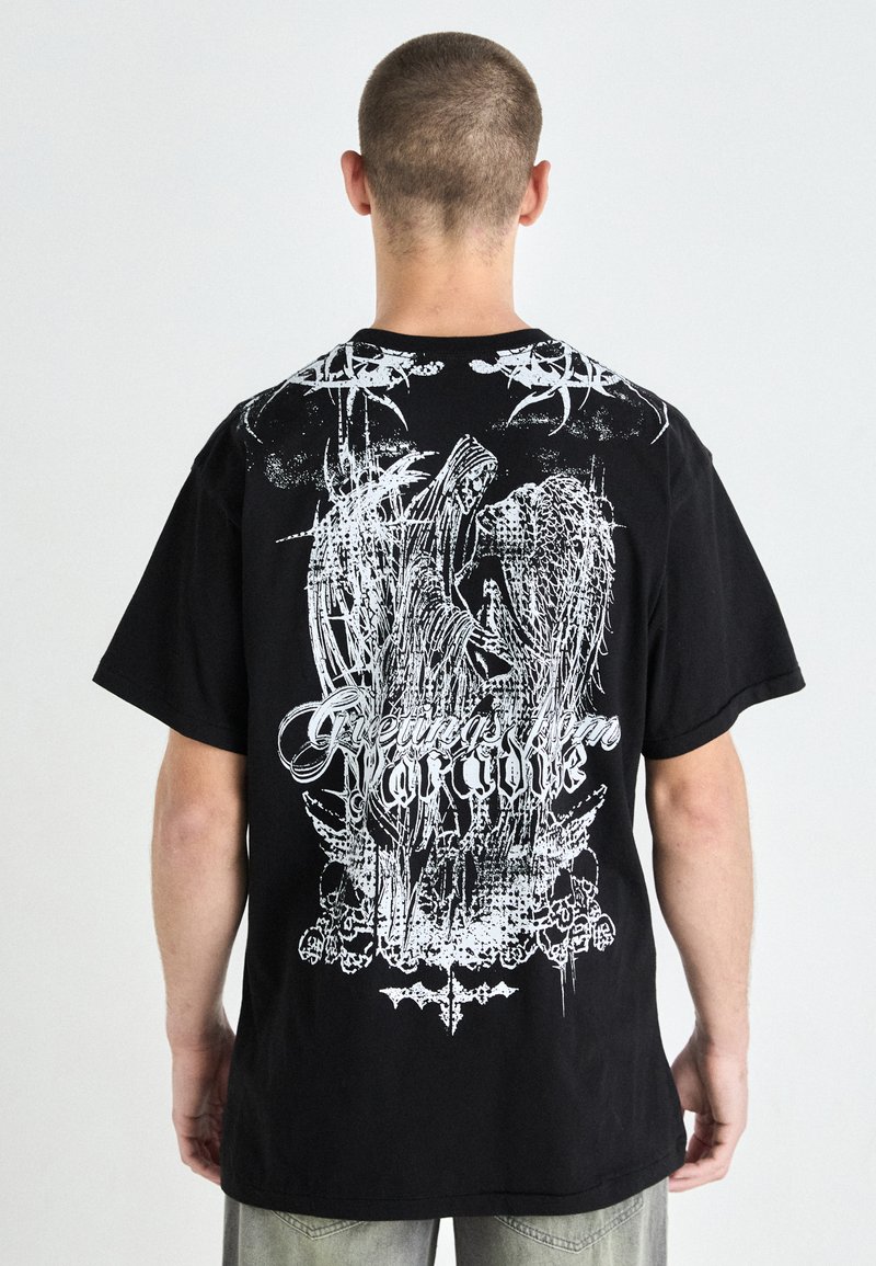 Black cotton t-shirt with a large white graphic on the back featuring the text "Greetings from Paradise" and intricate designs.