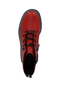 Stivale alla caviglia in pelle rossa con lacci neri, punta rotonda, cuciture bianche e una linguetta per indossarlo. Texture liscia e design strutturato.