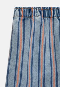Prugasta tkanina u plavoj i narančastoj boji, s naboranim pojasom i mekom denim teksturom s vidljivim detaljima šivanja.