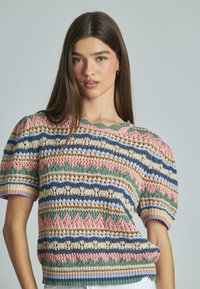 Gebreide trui met korte mouwen, voorzien van meerkleurige patronen in roze, groen, blauw en crème, met een gekartelde kraag en geribbelde zoom.