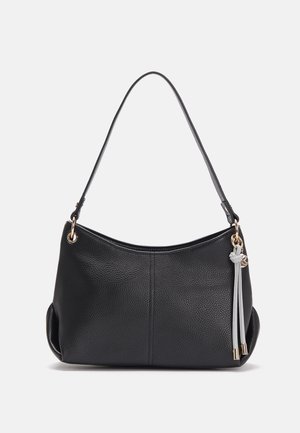 Sac à épaule en cuir noir texturé avec une bandoulière simple et un détail de pompon gris suspendu près de l'anneau métallique doré sur le côté.