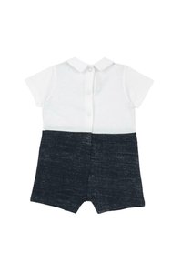 Combinaison à manches courtes avec un haut en coton blanc et un bas en denim foncé. Fermeture à boutons au dos ; short droit avec une finition texturée.