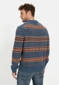 Knitted sweater in blue with brown and cream patterned stripes, featuring thick ribbed hem and cuffs. Warm wool blend material.