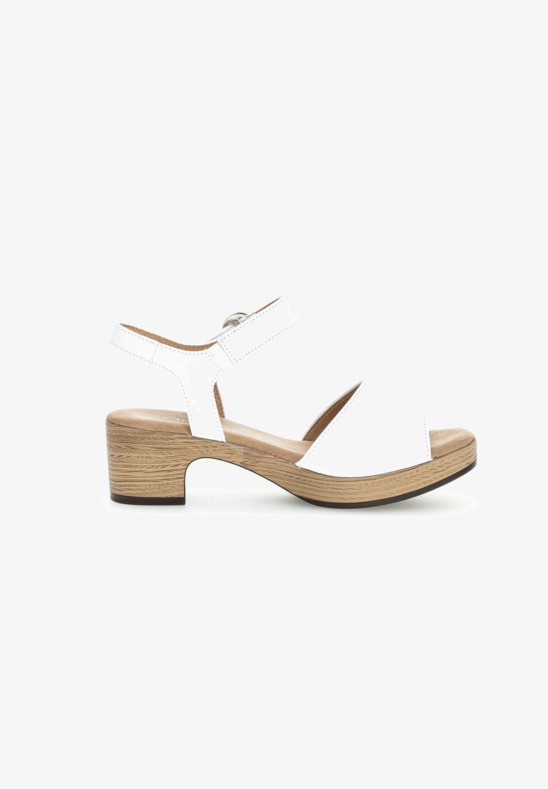 Sandalo bianco da donna con punta aperta, cinturino regolabile alla caviglia, tacco basso a blocco in legno e soletta imbottita su sfondo bianco.