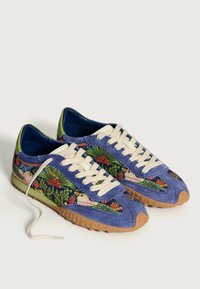 Sneaker blu in suede con ricami di uccelli e fiori, lacci crema, accenti verdi e suola in gomma testurizzata color beige.