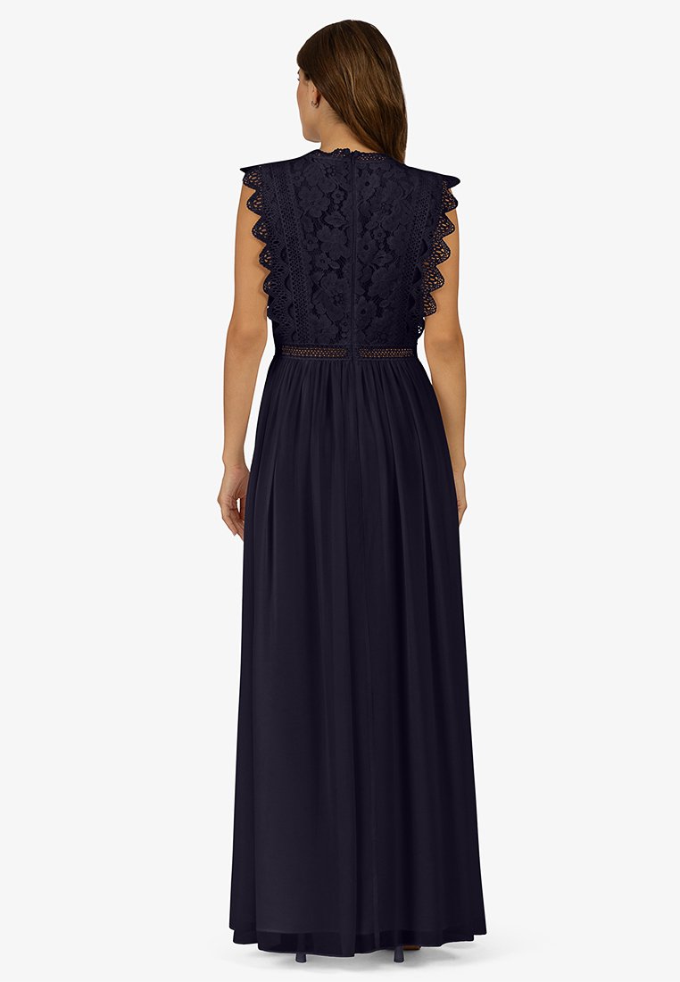 Robe maxi bleu marine avec des détails en dentelle sur le buste, des manches à volants et une taille cintrée, se déversant en une jupe plissée.