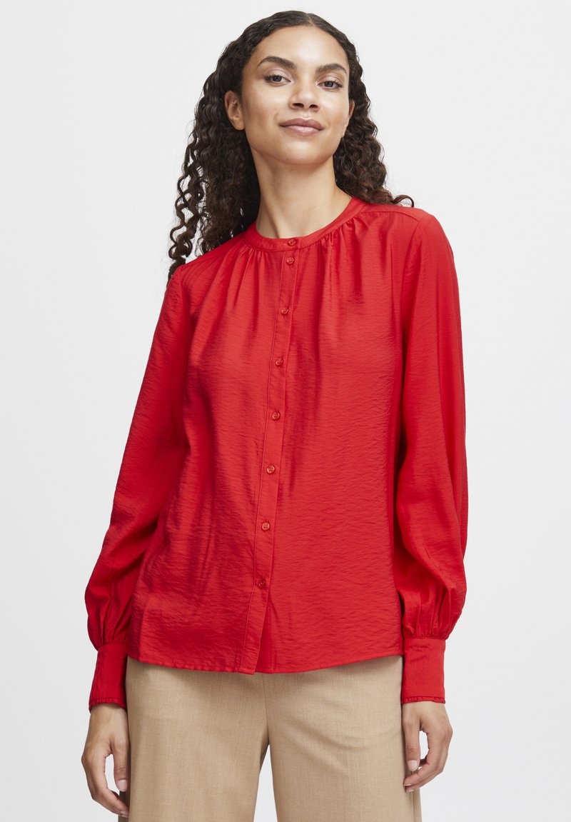 Rote Bluse mit Knopfleiste und langen Ärmeln, gerafftem Halsauschnitt und strukturiertem Stoff. Verfügt über passende Knöpfe und einen lässigen Schnitt.