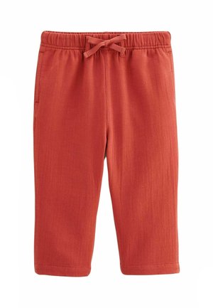 Shorts de sport en coton rouge avec une taille élastique et un cordon de serrage. Comprend des poches latérales et une texture côtelée sur l'ensemble du tissu.