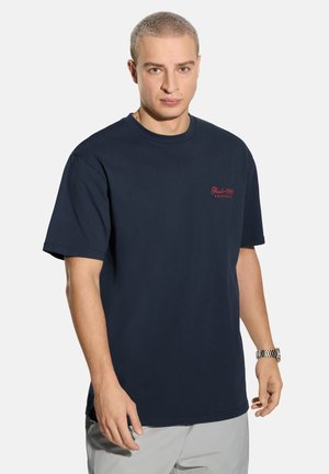 Granatowy bawełniany t-shirt z krótkimi rękawami, okrągłym dekoltem i czerwonym wyhaftowanym logo na piersi. Prosty i klasyczny krój.