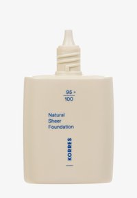 KORRES Naturale Sheer Foundation in einem quadratischen, cremefarbenen Behälter mit blauer Schrift; verfügt über eine Drehkappe mit einer Düse zur Dosierung.