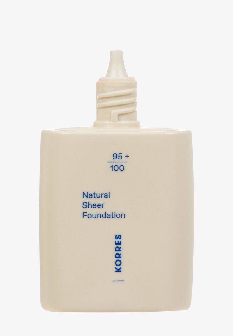 KORRES Naturale Sheer Foundation in einem quadratischen, cremefarbenen Behälter mit blauer Schrift; verfügt über eine Drehkappe mit einer Düse zur Dosierung.