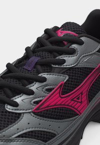 Μαύρο και γκρι δρομικό παπούτσι με πλέγμα, με χοντρά μαύρα κορδόνια και ένα εμφανές ροζ λογότυπο στο πλάι.