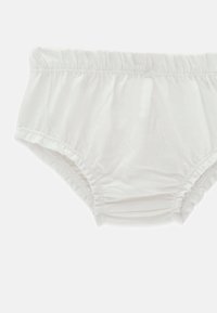 Sous-vêtement avec ceinture élastique blanche, tissu froncé et ouvertures extensibles aux jambes sur fond blanc uni.